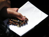 Hand, rosary and paper