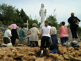 Women kneeling before the Statue of Queen of Peace at Apparition Hill